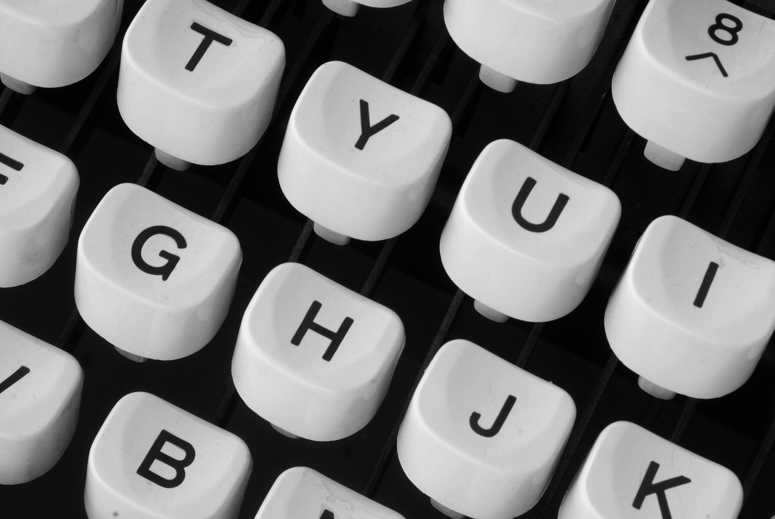 Black and white close-up of retro typewriter keys showcasing vintage charm.